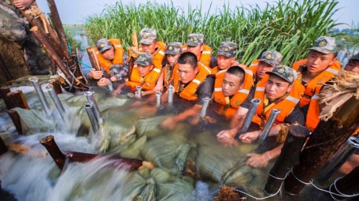 Chinese soldiers use their bodies to stop furious floodwaters from entering a city 