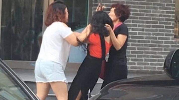 Chinese woman attacks her husband's mistress by ripping her clothes and cutting her hair