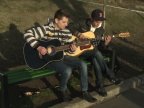 Outdoor concert near the lake. Young people perform for passersby