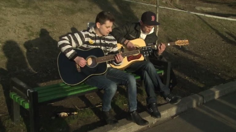 Outdoor concert near the lake. Young people perform for passersby