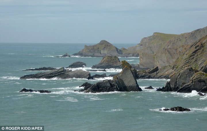 Two young men clinging to rocks were plucked to safety from sea by helicopter 