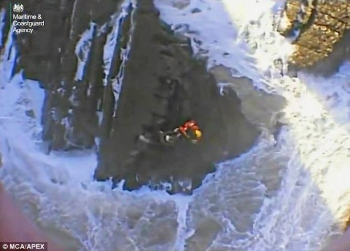 Two young men clinging to rocks were plucked to safety from sea by helicopter 