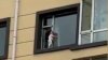 Horrifying! Chinese toddler balanced on the tiny ledge out of a five-storey window