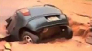 S-a crăpat pământul. Cum dispare o maşină în craterul produs pe o şosea VIDEO