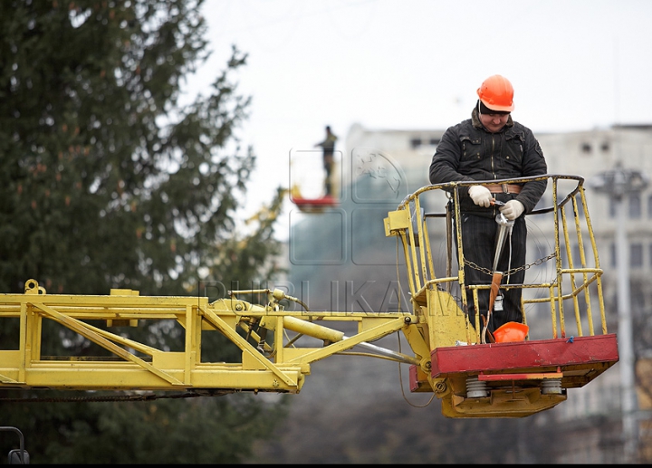 Chişinăul a intrat în febra sărbătorilor de iarnă. Oraşul este îmbrăcat în mii de beculeţe, iar bradul - împodobit cu globuri (FOTO)