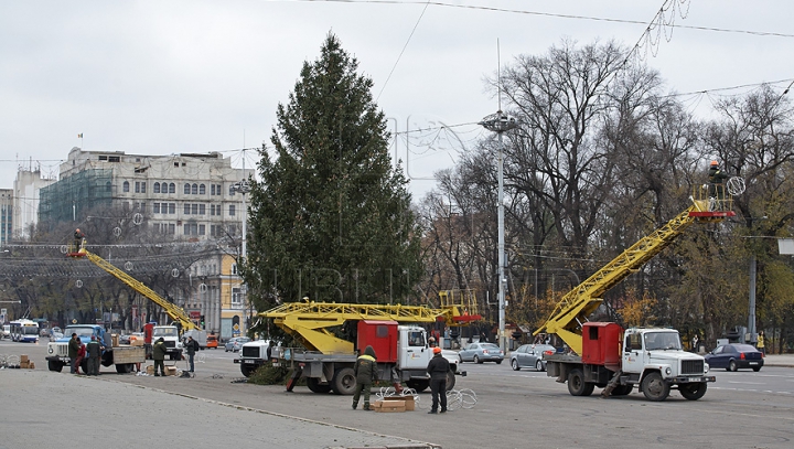 Chişinăul a intrat în febra sărbătorilor de iarnă. Oraşul este îmbrăcat în mii de beculeţe, iar bradul - împodobit cu globuri (FOTO)