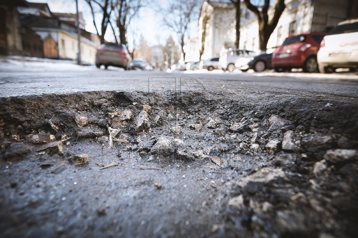 Şoferii circulă din groapă în hop. Cât de adânci sunt craterele asfaltului din Chişinău (FOTO)