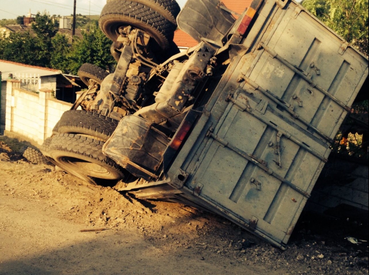 ACCIDENT GRAV la Străşeni. Un camion A DĂRMAT gardul unei gospodării şi S-A RĂSTURNAT (FOTO)