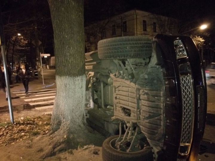 Un SUV de lux s-a răsturnat în centrul Capitalei. ŞOFERIŢA a fugit de la faţa locului (FOTO/VIDEO)