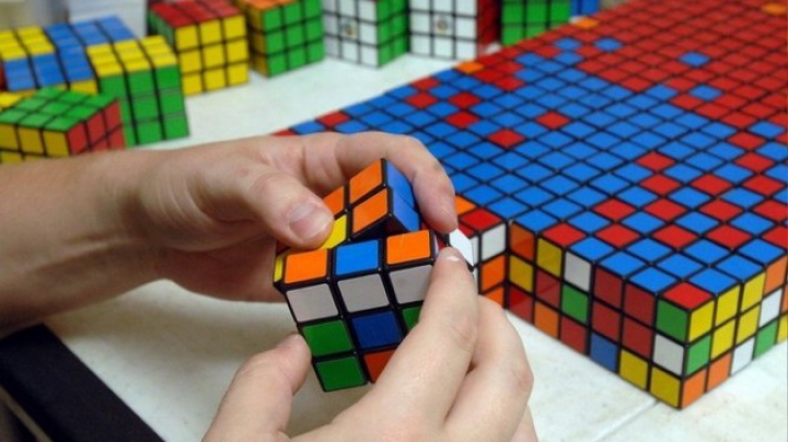 VIRAL pe Internet. Un bărbat rezolvă simultan trei cuburi Rubik în 20 de secunde (VIDEO)