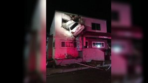 CU MAŞINA, LA ETAJ. Doi oameni din SUA au scăpat ca prin minune după ce autoturismul în care se aflau s-a izbit violent de o clădire