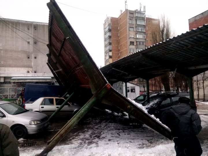 Două maşini, grav avariate, după ce un acoperiş metalic a căzut peste ele (FOTO)