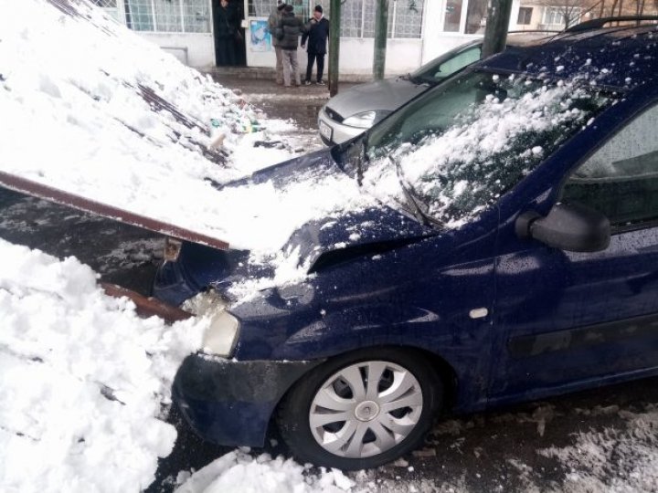 Două maşini, grav avariate, după ce un acoperiş metalic a căzut peste ele (FOTO)
