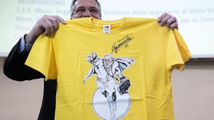 Un tricou cu un desen reprezentându-l pe Papa Francisc zburând ca Superman va fi scos la licitaţie pentru a finanţa mai multe acţiuni caritabile