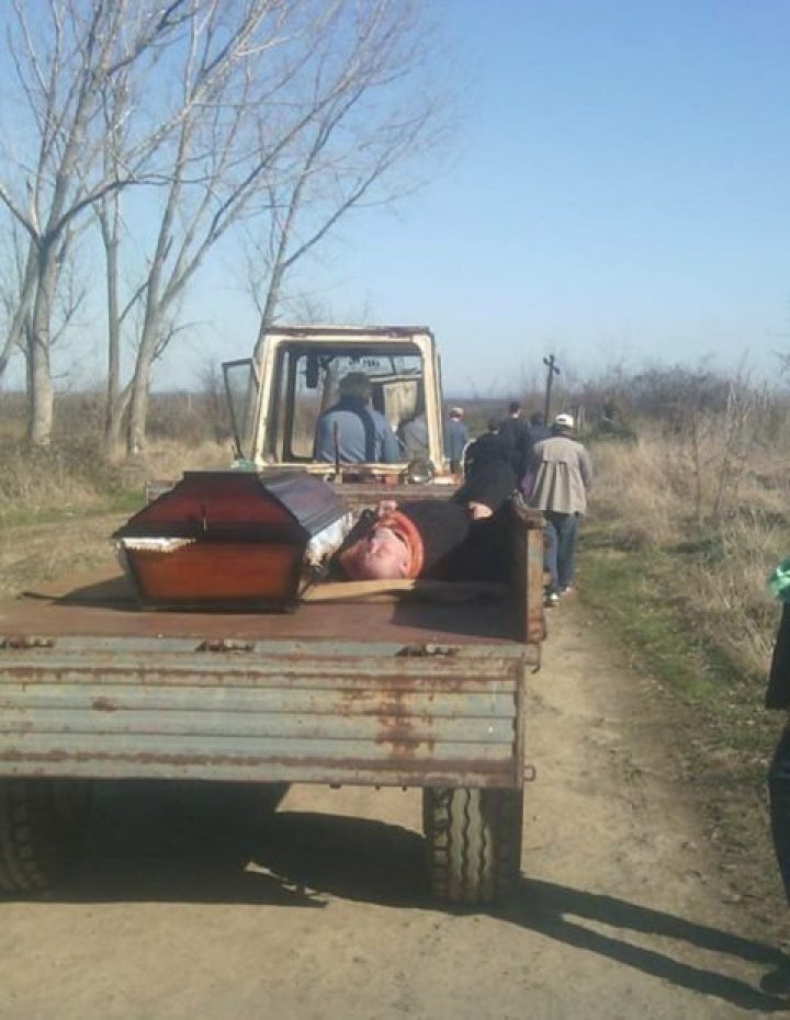 SCANDALOS! Un PREOT BEAT CRIŢĂ, pus de săteni lângă un sicriu și cărat într-o remorcă până la cimitir (FOTO)