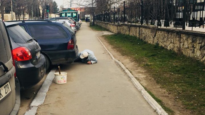 POZA ZILEI: Modul în care un muncitor vopsea bordura cu var pe o stradă din Capitală 