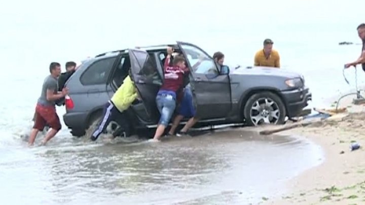 Nebunie și distracție de 1 Mai în Vama Veche din România. Momentul în care mai mulți tineri fac prima baie în mare, cu mașina (VIDEO)