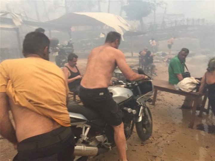 (IMAGINI DIN DRONĂ CARE FAC ÎNCONJURUL LUMII) Oameni și animale fug spre mare din calea flăcărilor, în Grecia