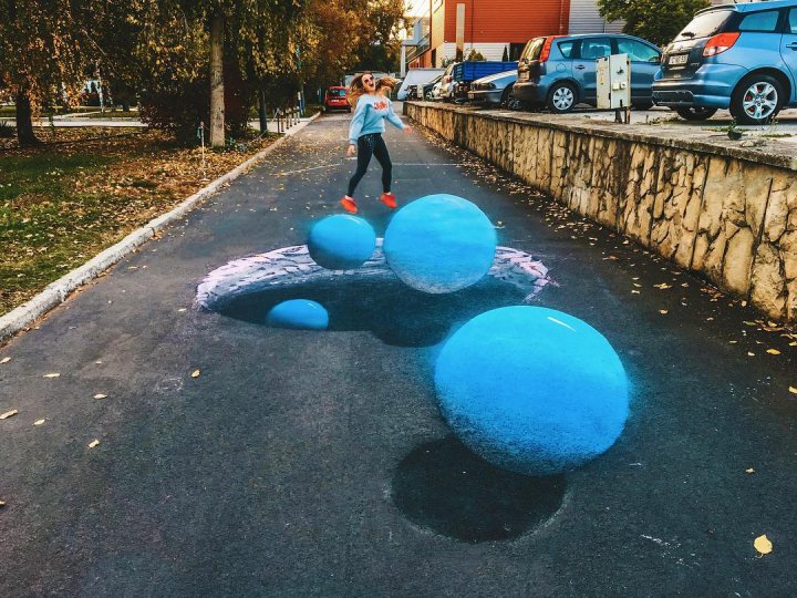 Cosmosul de pe asfalt. Desenul 3D realizat de o tânără din Capitală, o adevărat o artă ce impresionează trecătorii (FOTO)