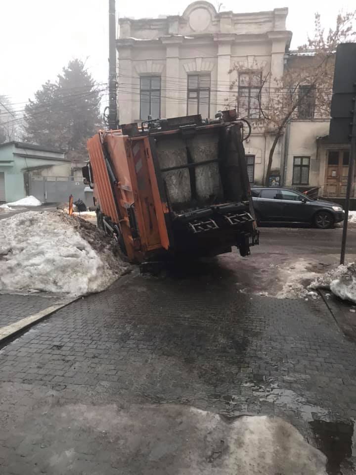 Se prăbușește asfaltul! O mașină de gunoi, BLOCATĂ într-o groapă în sectorul Centru al Capitalei (FOTO)  