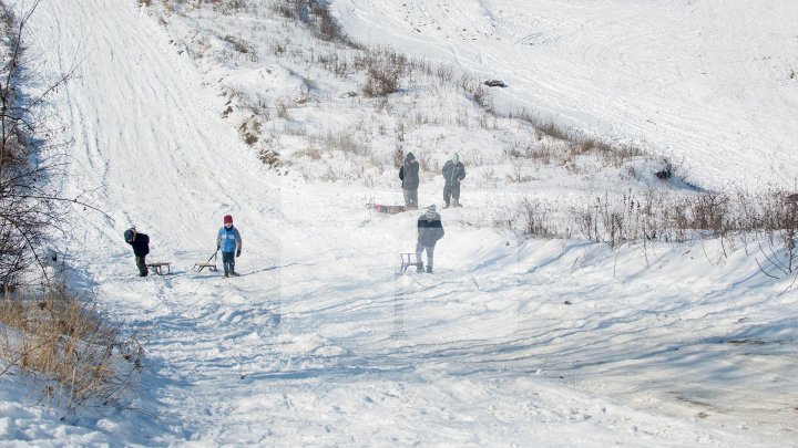 Ninsorile au creat PEISAJE DE POVESTE. Adulţii admiră splendoarea iernii, iar copiii se distează pe pârtii improvizate (FOTO)