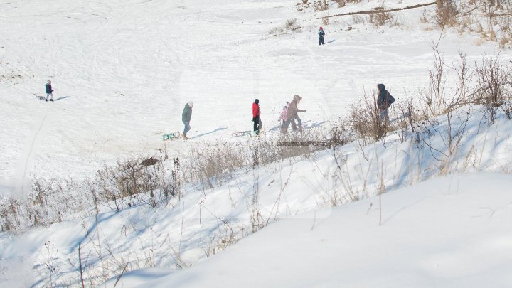 Ninsorile au creat PEISAJE DE POVESTE. Adulţii admiră splendoarea iernii, iar copiii se distează pe pârtii improvizate (FOTO)