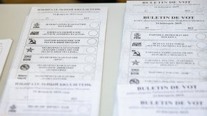 La o secţie de votare din Ialoveni, membrii comisiei electorale oferă cetăţenilor doar două buletine de vot