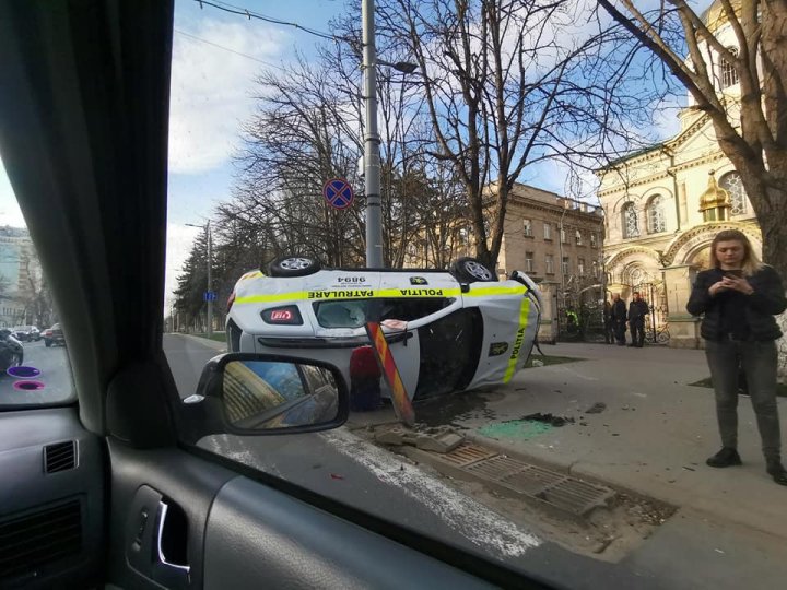 Accident cu implicarea unei mașini de poliție: S-a ciocnit cu un alt automobil și s-a răsturnat ( VIDEO)