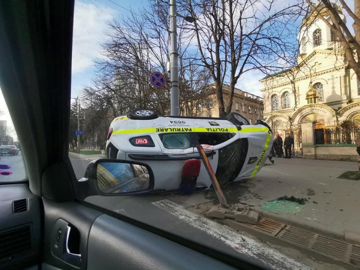 Accident cu implicarea unei mașini de poliție: S-a ciocnit cu un alt automobil și s-a răsturnat ( VIDEO)