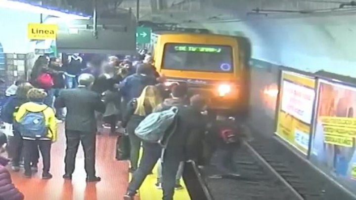 Imagini şocante! Momentul în care o femeie este salvată de la moarte, după ce un bărbat a leșinat și a împins-o în faţa unui tren (VIDEO)