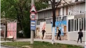Huliganism în plină zi: Aruncau cu pietre într-un trecător și au stricat geamul unui magazin (VIDEO)