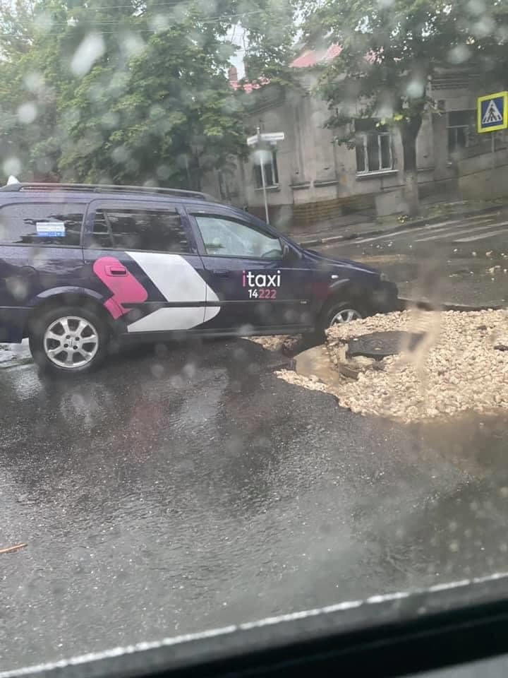 Un taxi, înghițit de o groapă imensă în Capitală (FOTO)