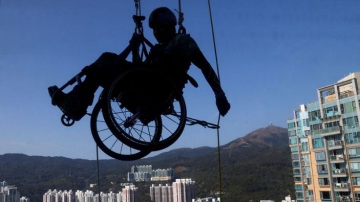 Un sportiv din Hong Kong a escaladat un zgârie-nori în scaun cu rotile