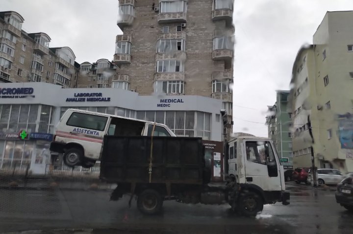 Scenă inedită, surprinsă pe străzile Capitalei. Vezi cum a fost transportată o ambulanță (FOTO)