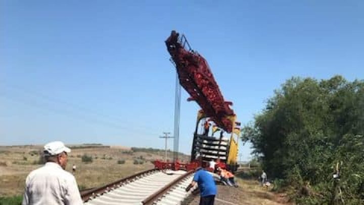 FOTO Primele imagini de la locul accidentului feroviar din sudul Moldovei. O macara ridică vagoanele cu grâu care s-au răsturnat