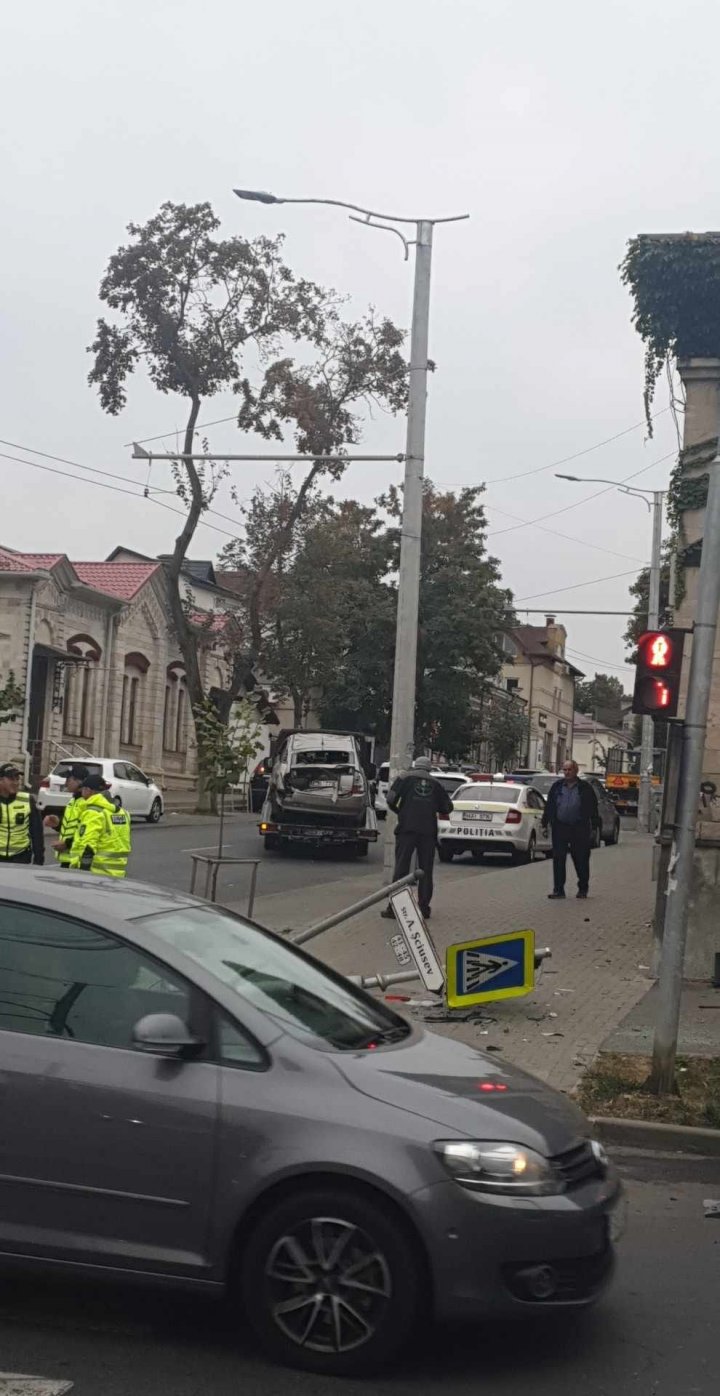 (FOTO) Impact violent între două mașini în centrul Capitalei. Două indicatoare au fost doborâte