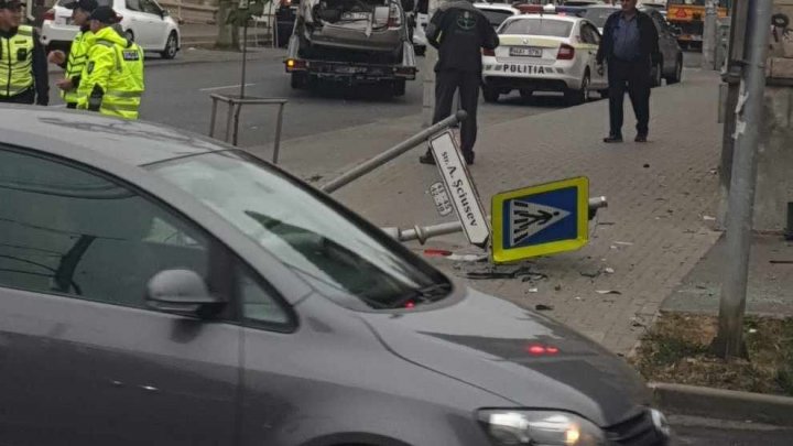 (FOTO) Impact violent între două mașini în centrul Capitalei. Două indicatoare au fost doborâte