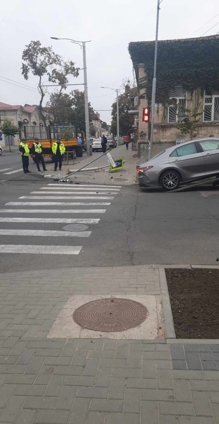 (FOTO) Impact violent între două mașini în centrul Capitalei. Două indicatoare au fost doborâte