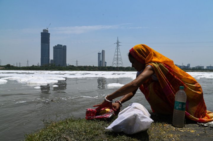 Spuma toxică a acoperit un râu sacru din India. Oamenii se scaldă, se roagă și beau apa otrăvită (FOTO)