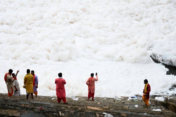 Spuma toxică a acoperit un râu sacru din India. Oamenii se scaldă, se roagă și beau apa otrăvită (FOTO)