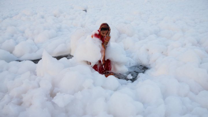 Spuma toxică a acoperit un râu sacru din India. Oamenii se scaldă, se roagă și beau apa otrăvită (FOTO)