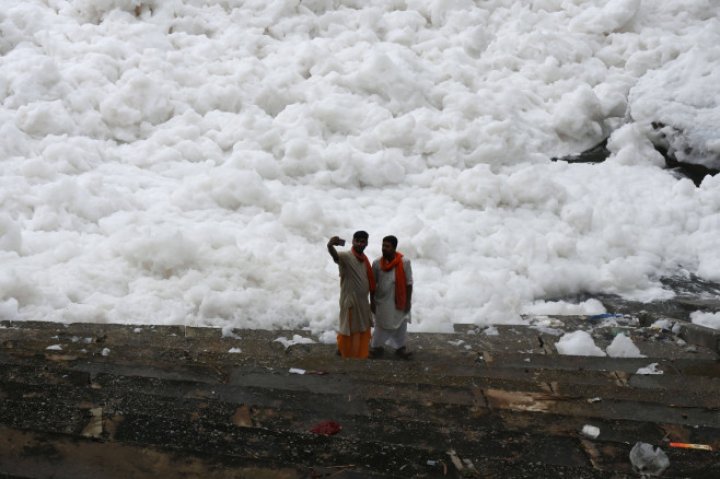 Spuma toxică a acoperit un râu sacru din India. Oamenii se scaldă, se roagă și beau apa otrăvită (FOTO)