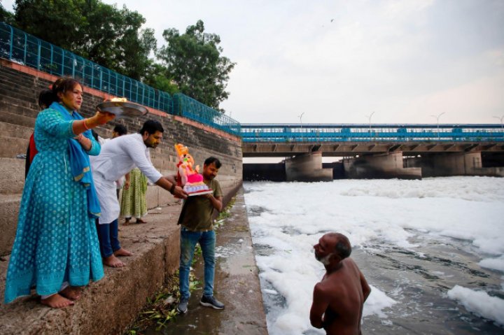 Spuma toxică a acoperit un râu sacru din India. Oamenii se scaldă, se roagă și beau apa otrăvită (FOTO)