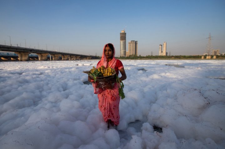 Spuma toxică a acoperit un râu sacru din India. Oamenii se scaldă, se roagă și beau apa otrăvită (FOTO)