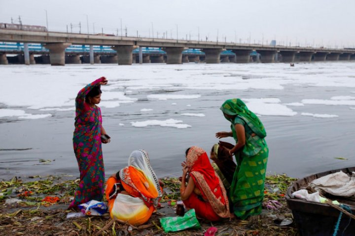 Spuma toxică a acoperit un râu sacru din India. Oamenii se scaldă, se roagă și beau apa otrăvită (FOTO)