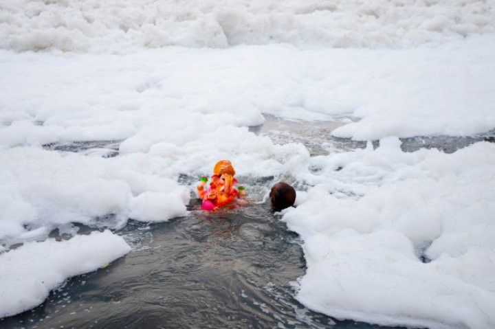 Spuma toxică a acoperit un râu sacru din India. Oamenii se scaldă, se roagă și beau apa otrăvită (FOTO)