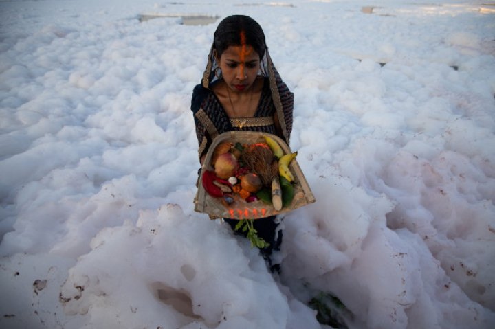 Spuma toxică a acoperit un râu sacru din India. Oamenii se scaldă, se roagă și beau apa otrăvită (FOTO)