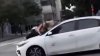 Momentul în care o femeie se agaţă de capota unui automobil în viteză pentru a-şi salva câinele. Animalul a fost furat de la o terasă