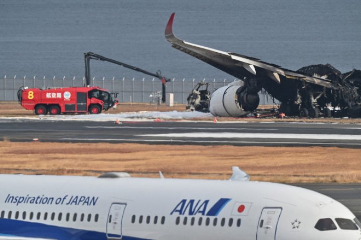 UN MORMAN DE FIARE! Imagini de pe aeroportul din Tokyo, cu epava înnegrită a avionului distrus ieri de flăcări. ŞOCAŢI, pasagerii au povestit cum s-au salvat