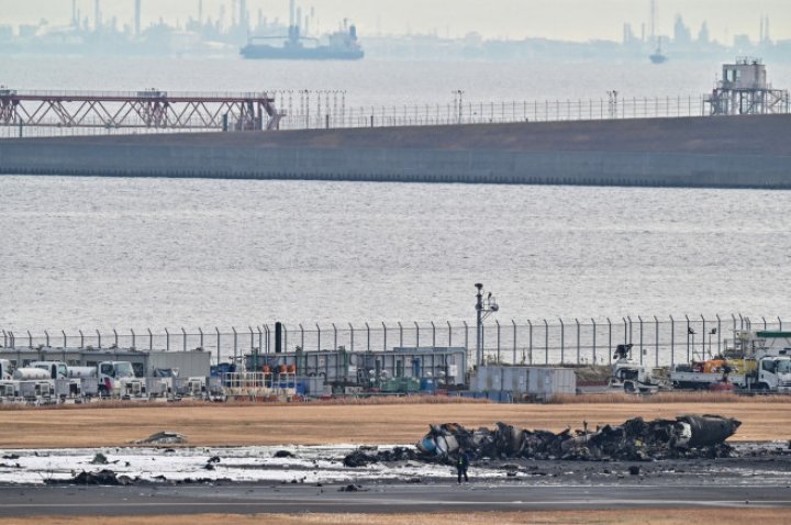 UN MORMAN DE FIARE! Imagini de pe aeroportul din Tokyo, cu epava înnegrită a avionului distrus ieri de flăcări. ŞOCAŢI, pasagerii au povestit cum s-au salvat